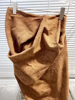 Нишевая коричневая юбка-трапеция с высокой талией и разрезом, облегающая бедра.